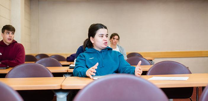 a student speaking in class while other students look on